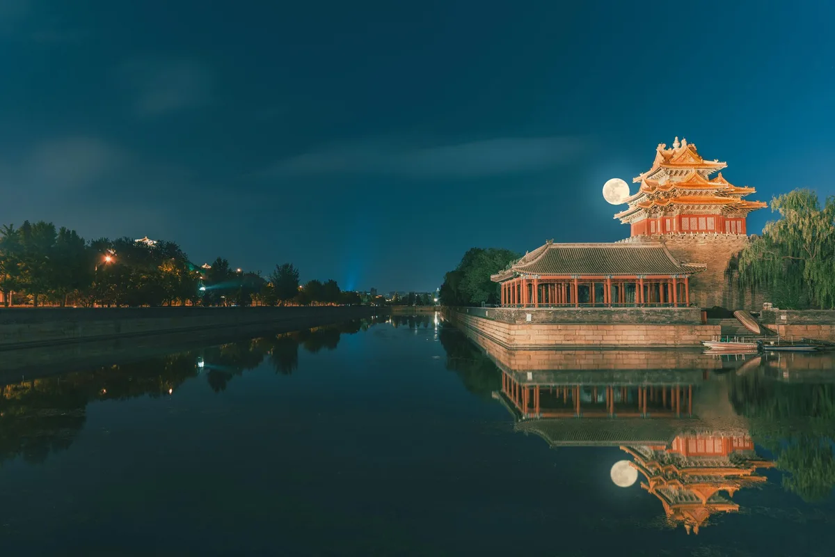 Forbidden City corner tower reflected in the moat at night