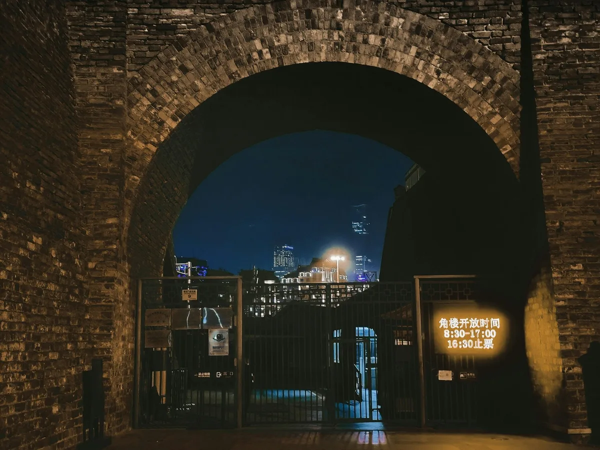 Beijing Ming City Wall ruins with city lights at night