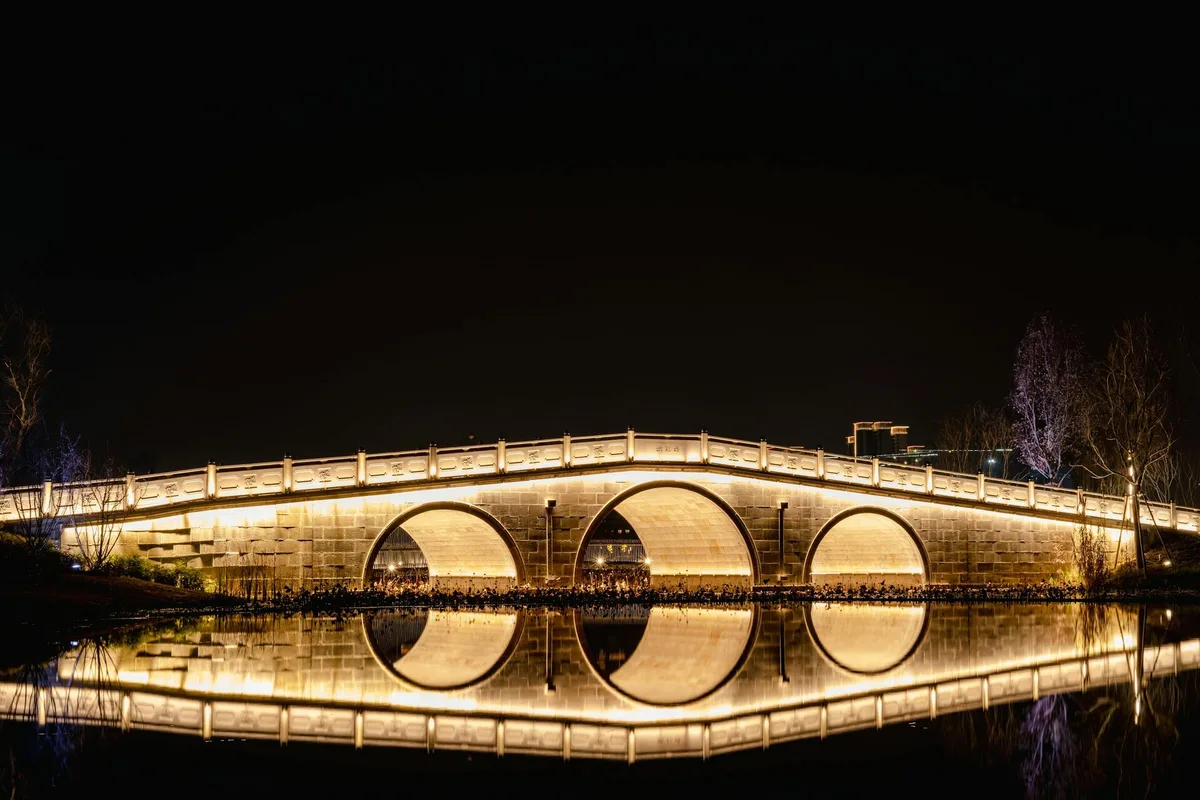Illuminated bridge and water reflection along Chengdu Jinjiang River