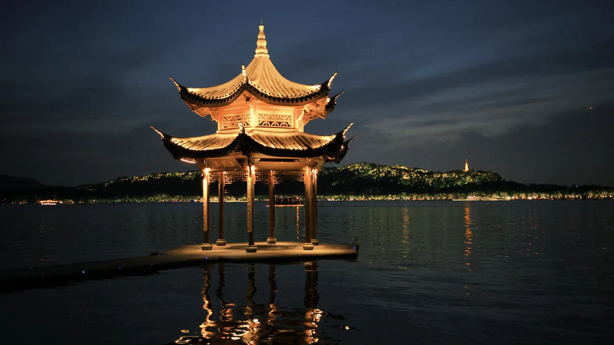 Jixian Pavilion illuminated beside West Lake at night