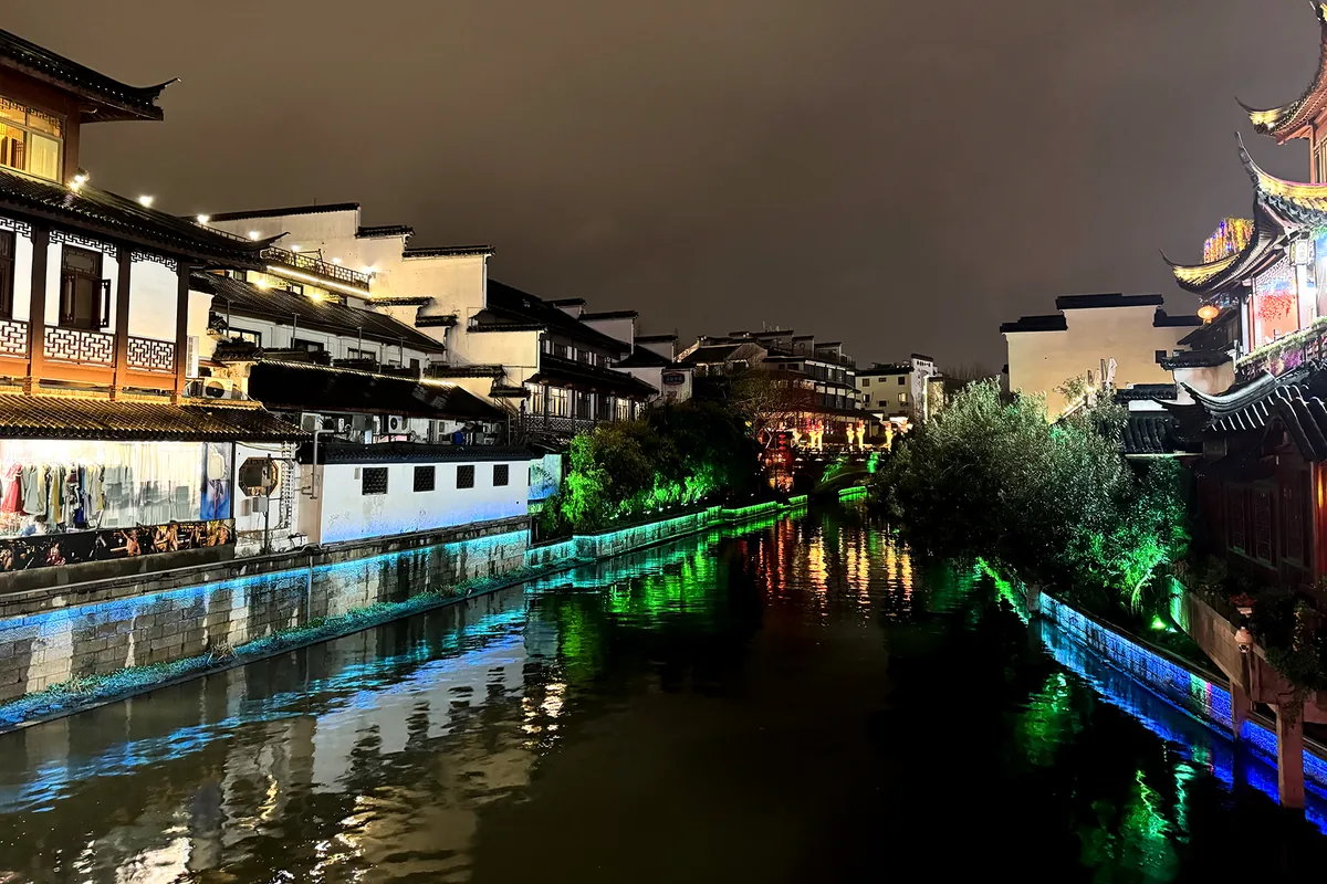 Qinhuai River reflections beside white-walled buildings at night