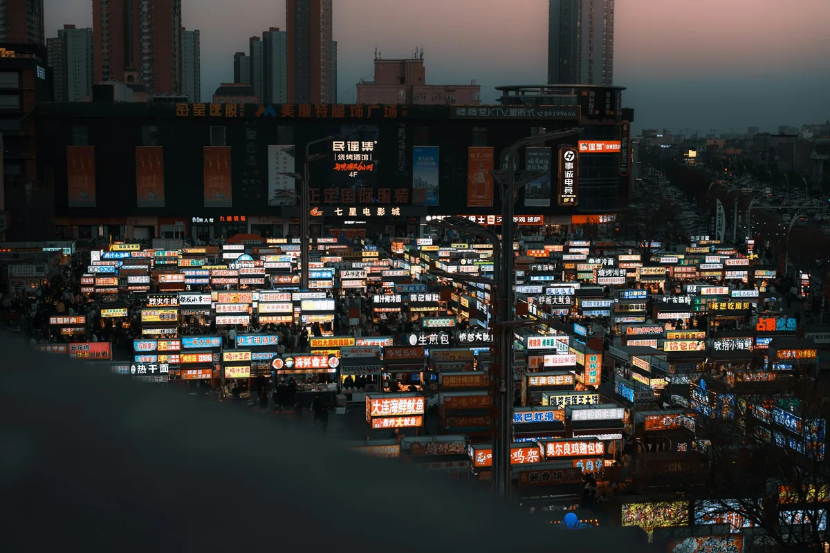 Zhengding night market street at dusk with neon signs