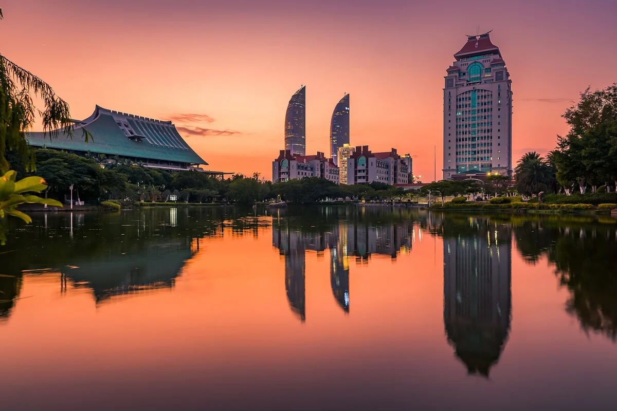 Xiamen University at dusk with city skyline lights