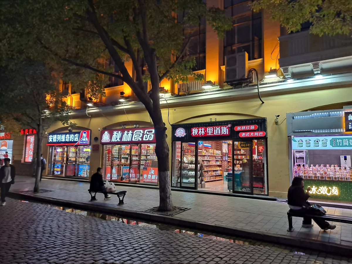 Storefront lights along Harbin Central Street at night