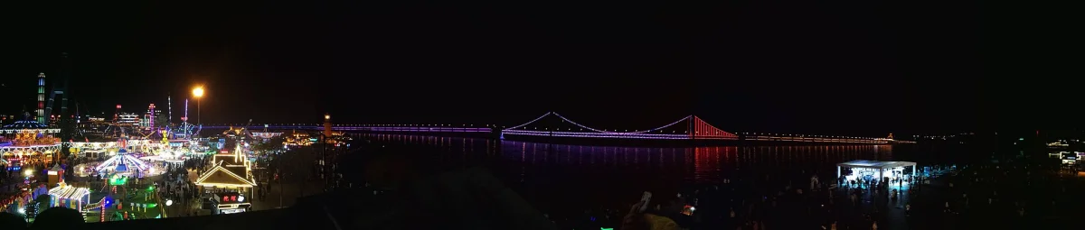 Xinghai Square and bridge lights in a wide Dalian night panorama