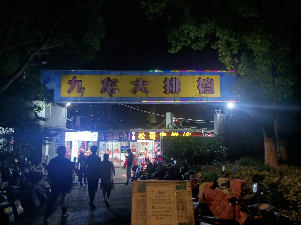 Kowloon food stall entrance with visitors in Changzhou at night