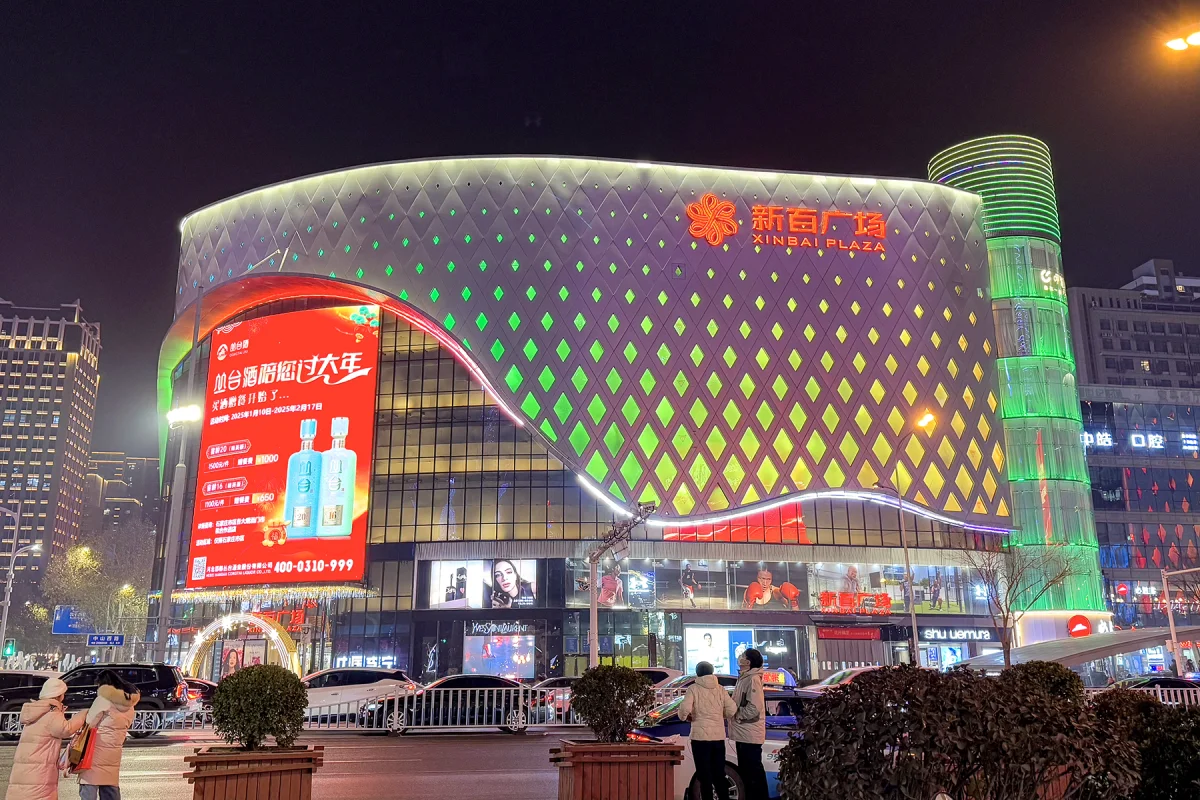 Xinbai Plaza rounded facade glowing at night in Shijiazhuang