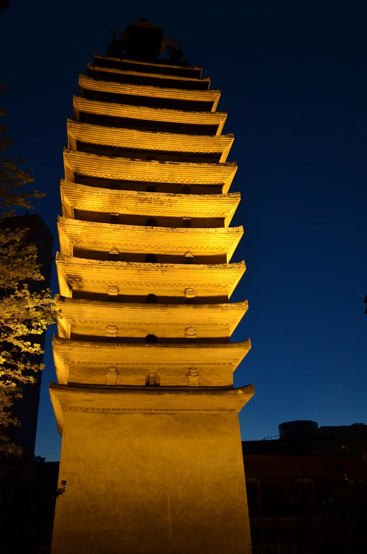 Kunming pagoda lit against a deep blue evening sky