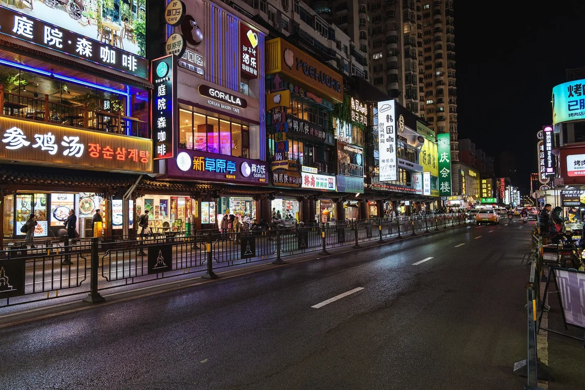 Restaurant signs and wet street reflections on Xita Street at night