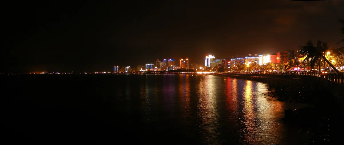 Sanya beachfront lights reflected across the water at night