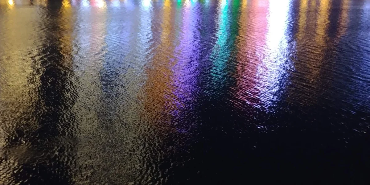 Colored city lights reflected on the Linchun River at night
