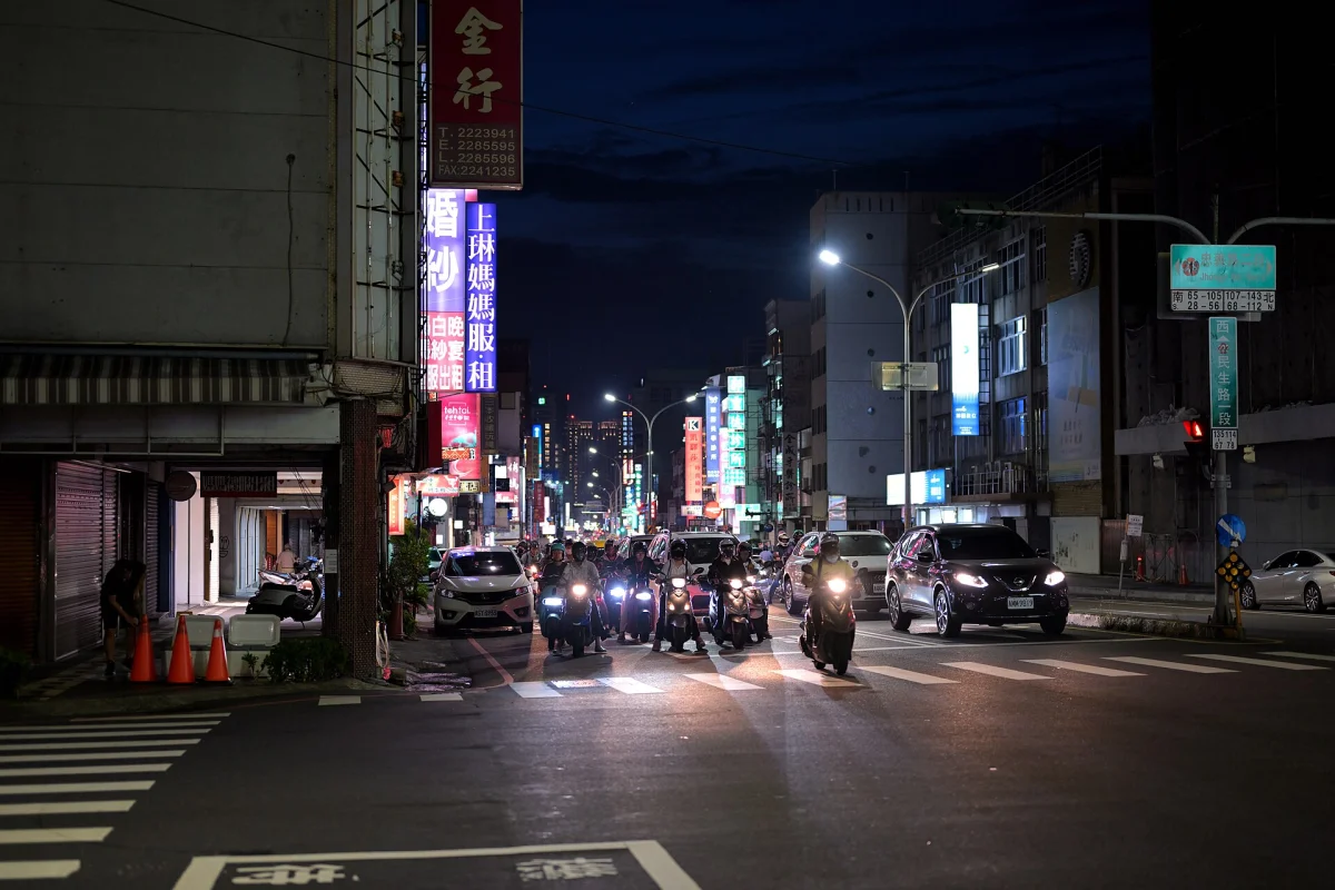 Scooters and lit shop signs on Minsheng Road in Tainan