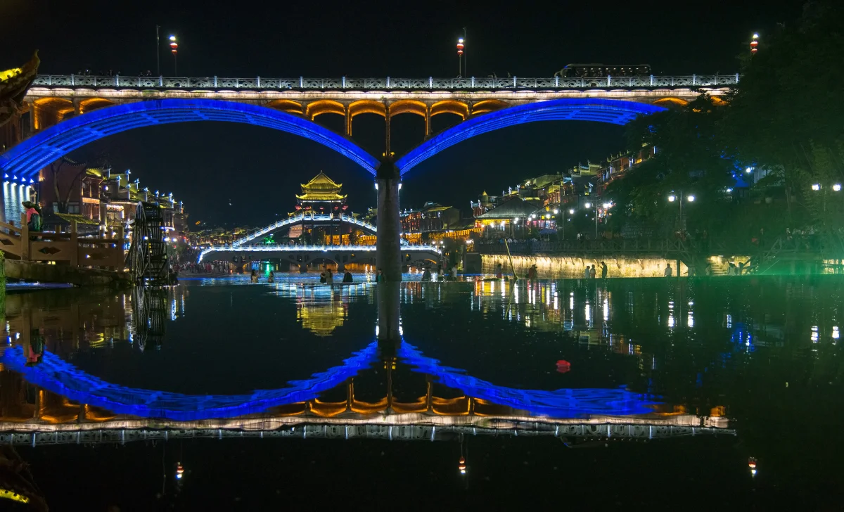 Symmetrical bridge reflections on the Tuojiang at night