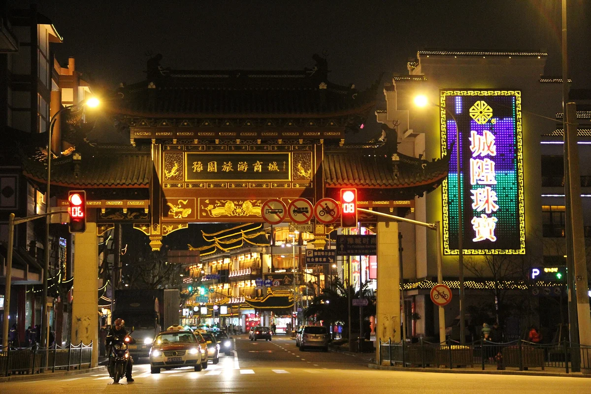 Old-city entrance arch beside Yuyuan Tourist Mart after dark