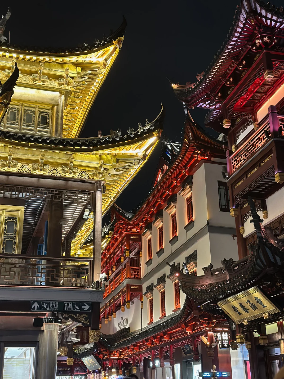 Gold and red rooflines above a narrow Yuyuan Old Street passage at night
